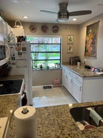 a kitchen with stainless steel appliances kitchen island granite countertop a sink dishwasher stove and cabinets