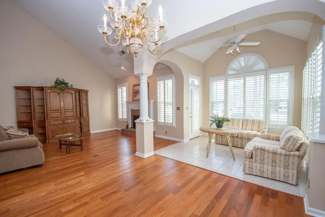 a living room with furniture chandelier and a large window