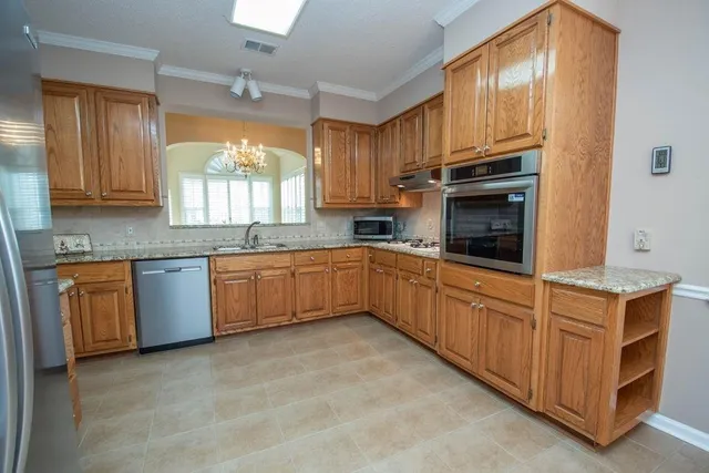 a kitchen with stainless steel appliances granite countertop a stove a sink dishwasher and a refrigerator