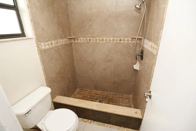 a bathroom with a toilet and a shower