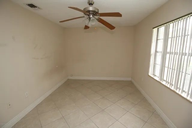 an empty room with a window and a fan