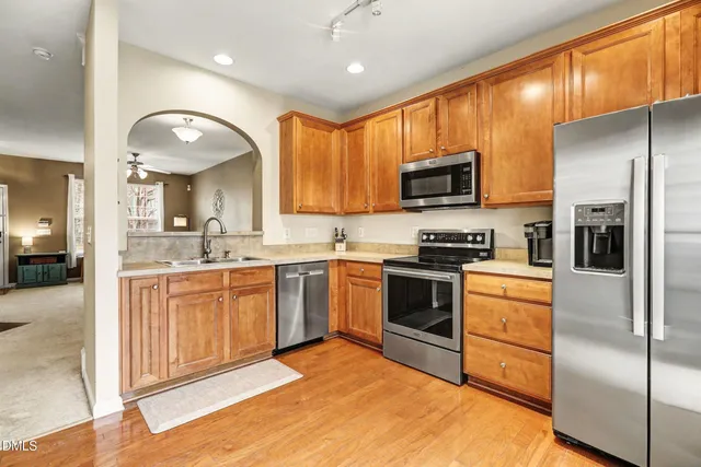 a kitchen with stainless steel appliances granite countertop a stove a sink and a refrigerator