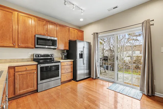 a kitchen with granite countertop a refrigerator stove top oven and sink