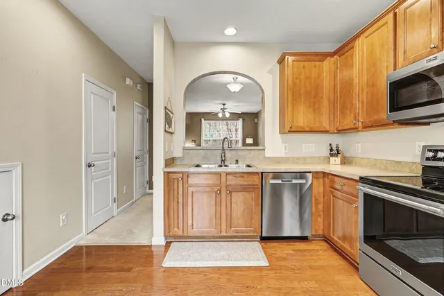 a large kitchen with stainless steel appliances granite countertop a stove a sink and a microwave