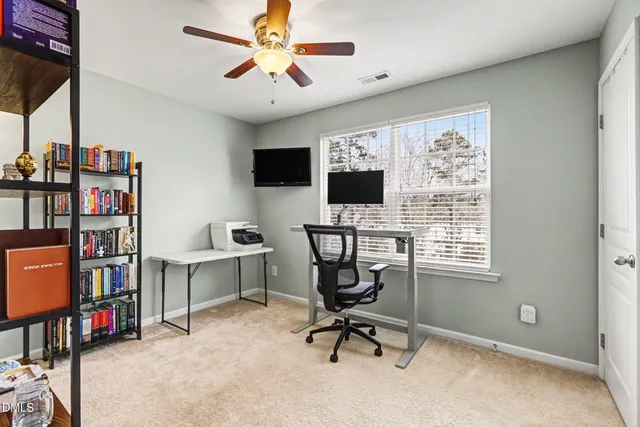 a view of a workspace with furniture and a window