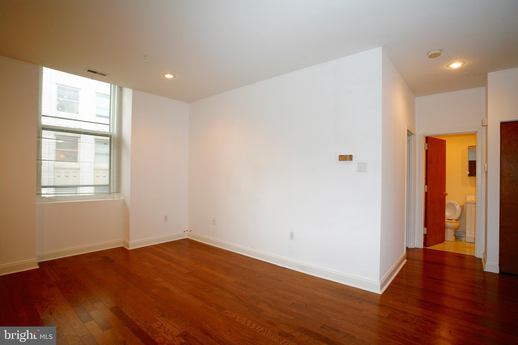 1600-5 Walnut Street, Unit 702 Philadelphia, PA 19103 - Photo 8 of 14 an empty room with wooden floor and windows