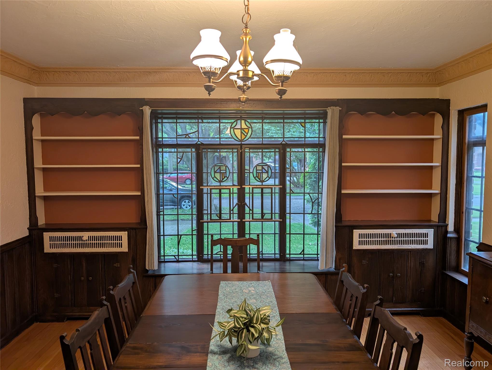 16580 Westmoreland Road Detroit, MI 48219 - Photo 8 of 37 Dining area featuring leaded and stained glass windows, built-in shelving and plaster crown moldings