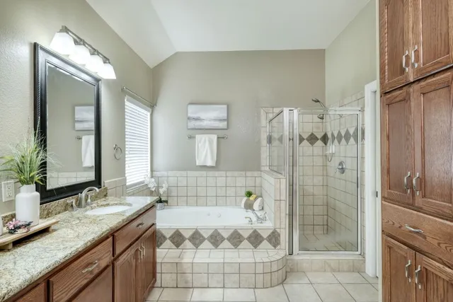 a bathroom with a granite countertop double vanity sink and a mirror