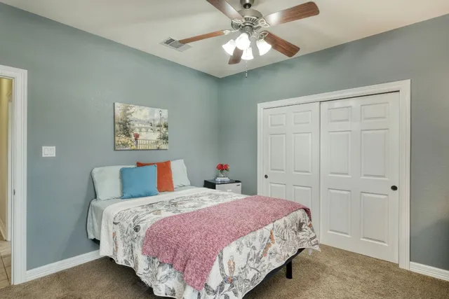 a bathroom with a granite countertop sink a toilet a mirror and shower
