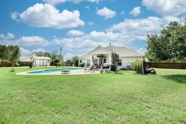 a view of a house with a backyard and garage