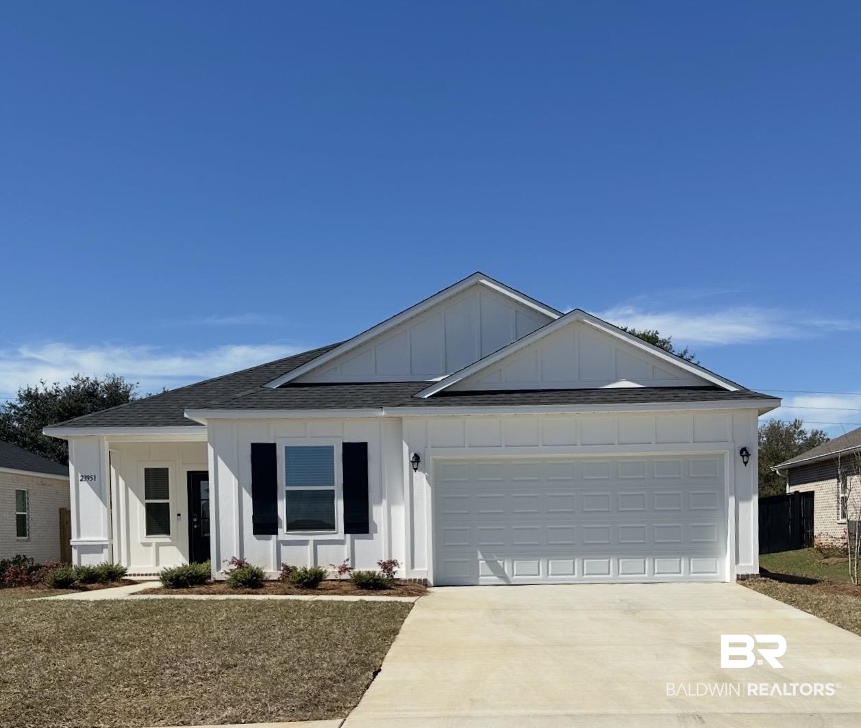 23951 Dominus Drive Daphne, AL 36526 - Photo 1 of 1 View of front facade with board and batten siding, a shingled roof, concrete driveway, and a garage