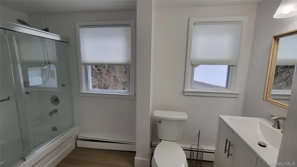 a bathroom with a sink a toilet and shower