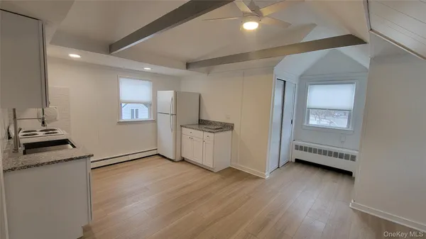 a view of a kitchen with wooden floor and a refrigerator