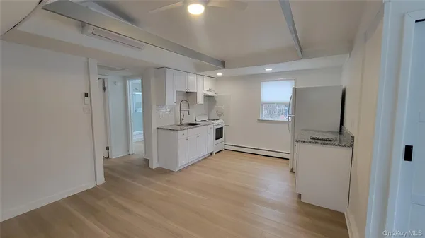 a view of a kitchen with a sink and refrigerator