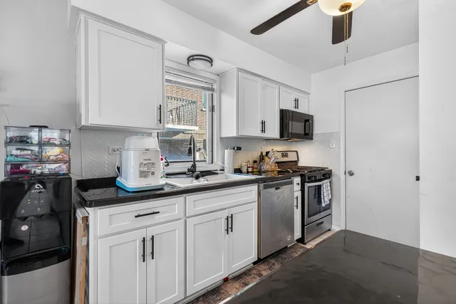 a kitchen with stainless steel appliances granite countertop a sink stove and cabinets