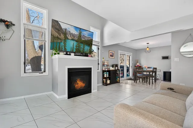 a living room with furniture a fireplace and a large window