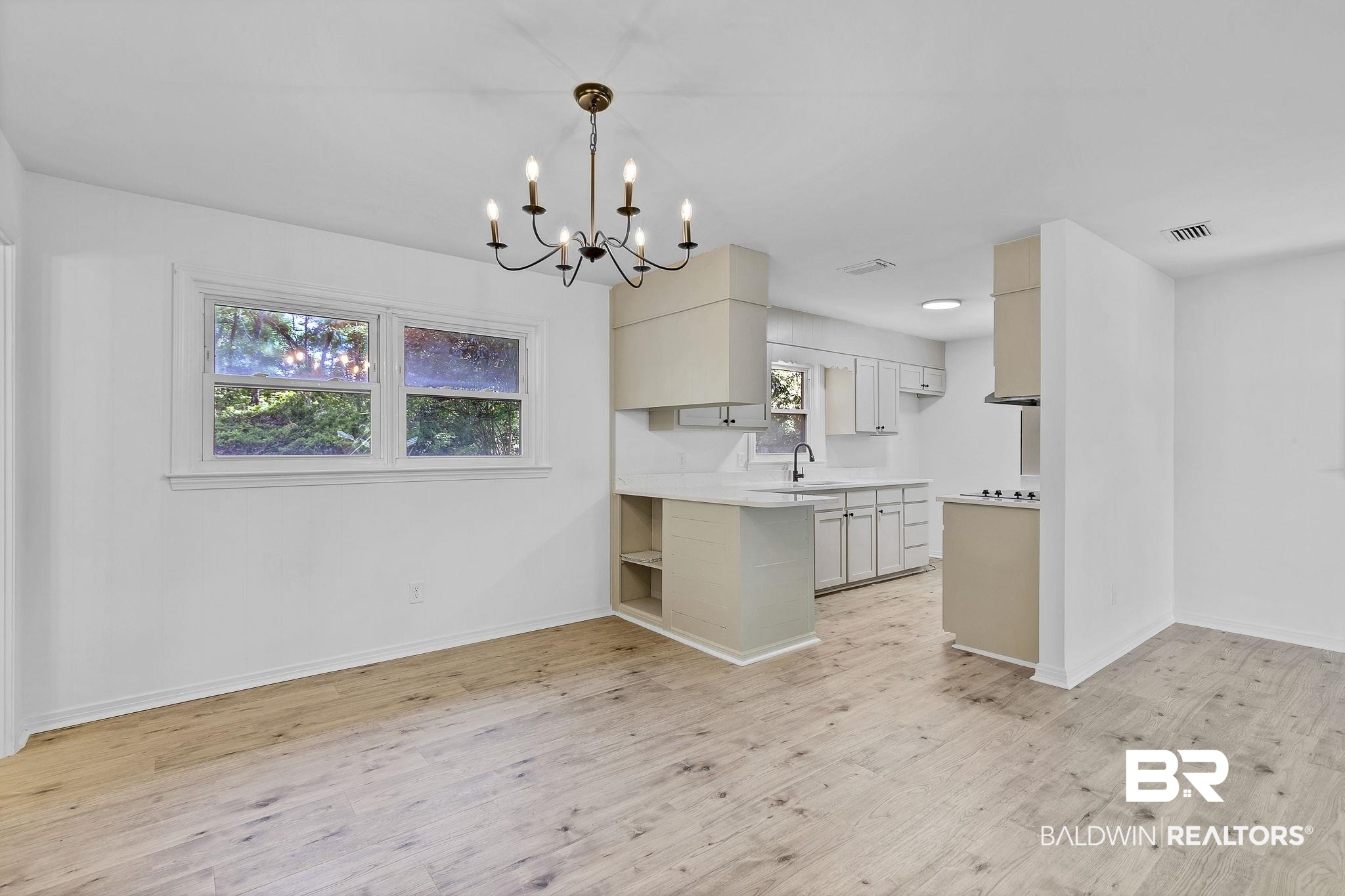 203 Anderson Road Saraland, AL 36571 - Photo 11 of 48 Kitchen featuring visible vents, an inviting chandelier, a sink, light countertops, and light wood-style flooring