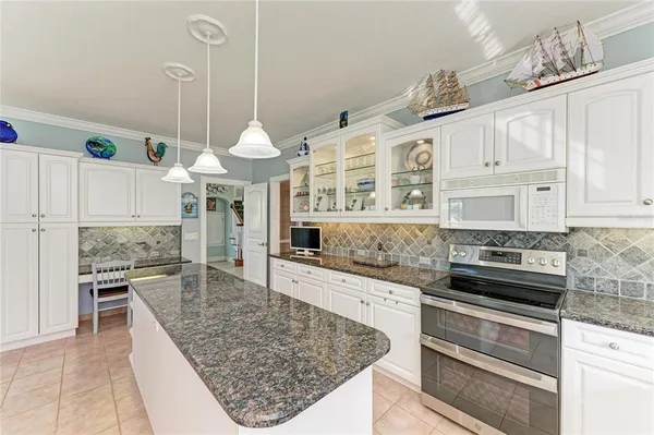 a kitchen with stainless steel appliances kitchen island granite countertop a refrigerator and a stove