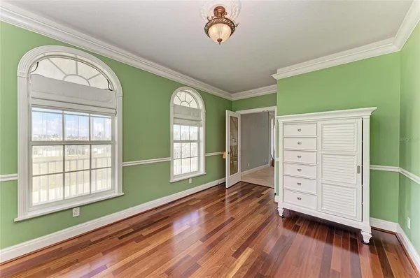 a view of a bedroom with a bed and wooden floor