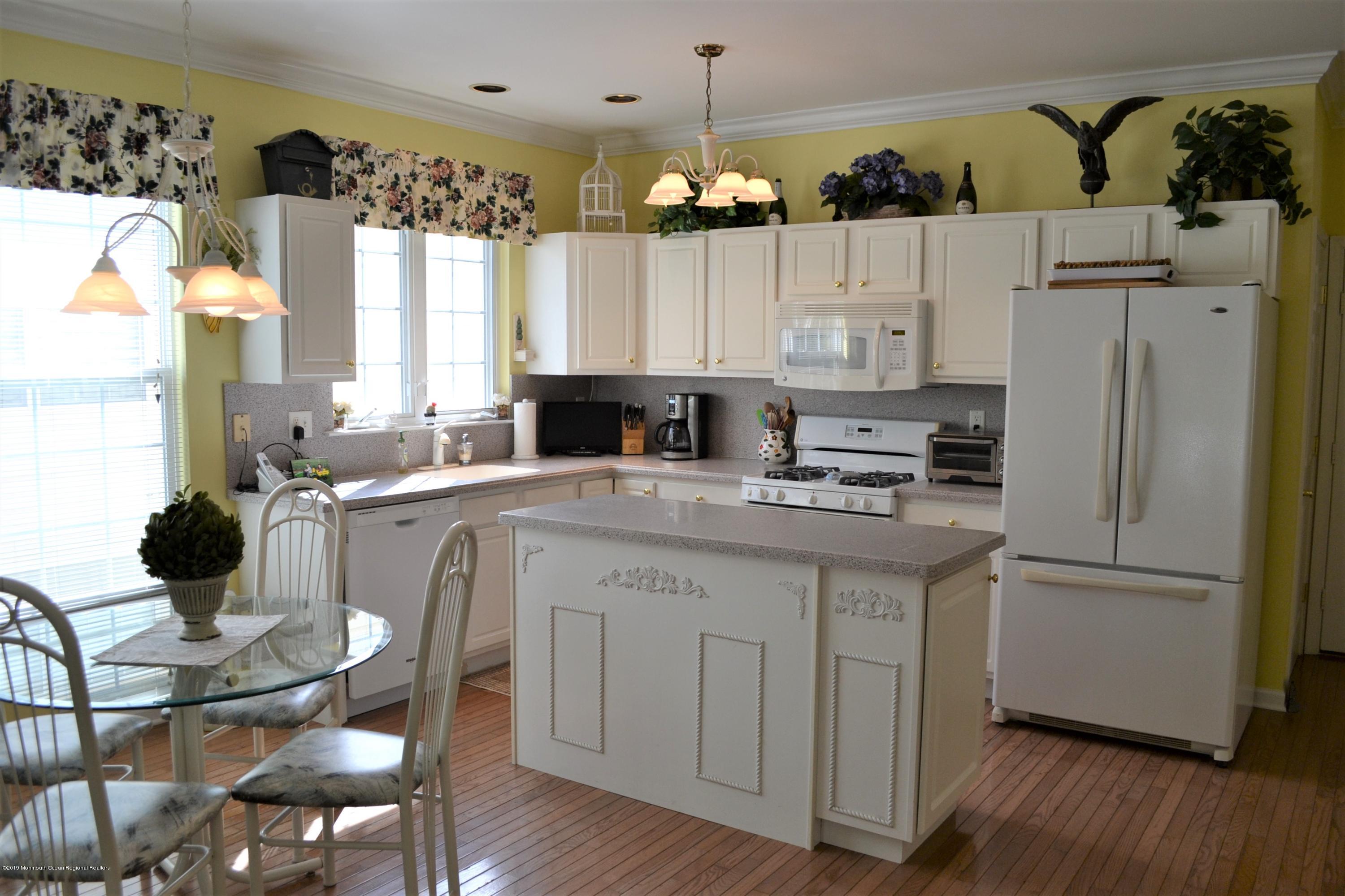 143 Wordsworth Road Brick, NJ 08724 - Photo 7 of 41 a kitchen with a refrigerator a stove a sink dishwasher and a dining table with wooden floor