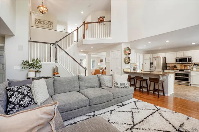 a living room with furniture kitchen view and a potted plant