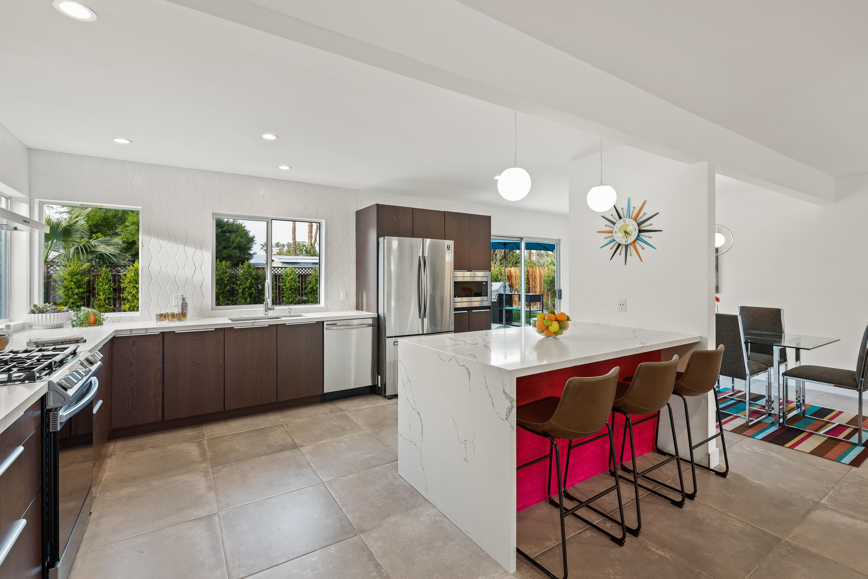 70170 Sun Valley Drive Rancho Mirage, CA 92270 - Photo 8 of 25 a kitchen with stainless steel appliances kitchen island granite countertop a refrigerator a stove a sink dishwasher and a dining table with the living room view