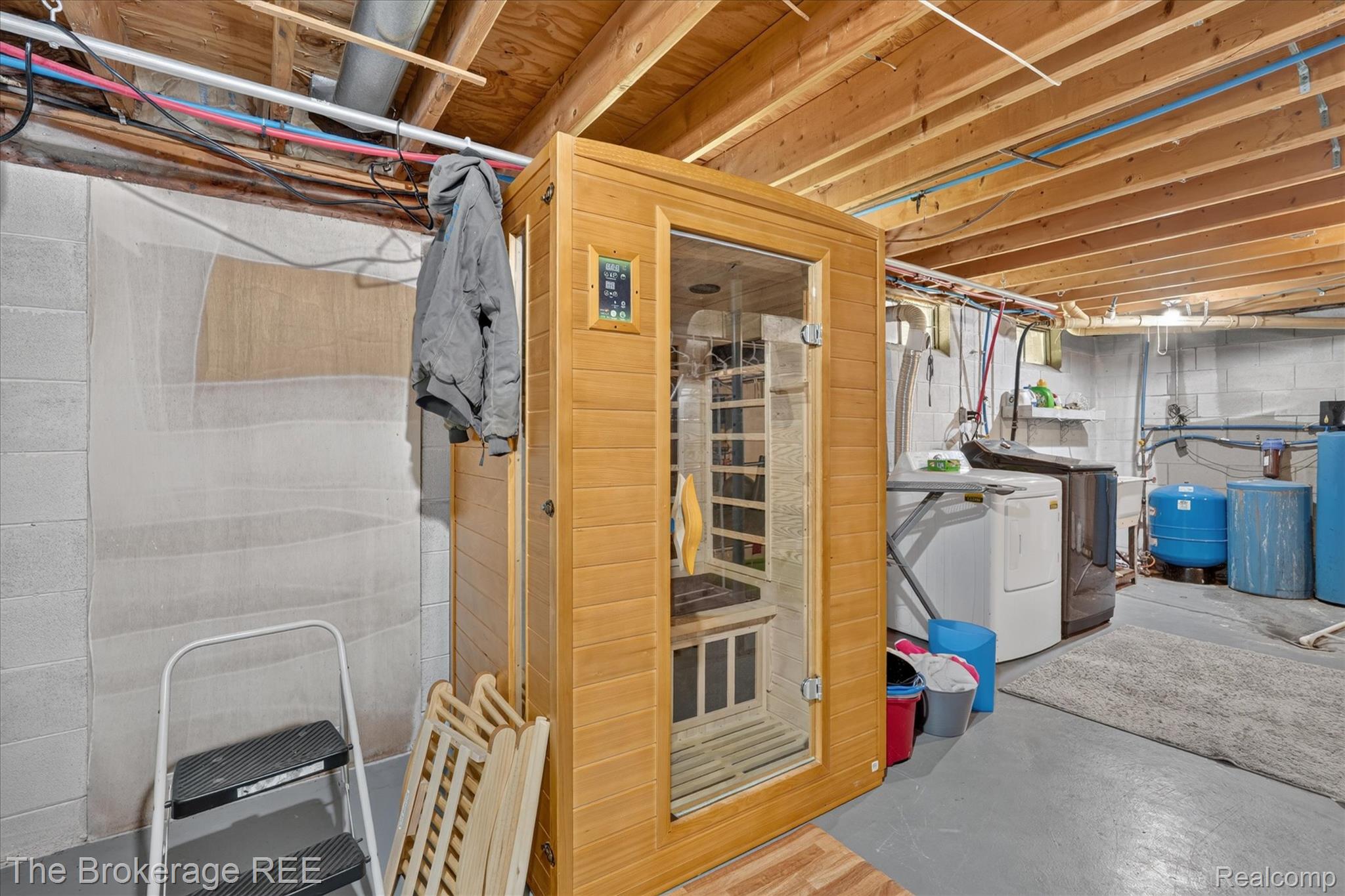 13269 North Genesee Road Clio, MI 48420 - Photo 41 of 67 Freestanding wood-finish sauna with a glass door, situated on gray concrete flooring