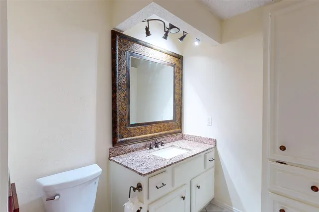 a bathroom with a granite countertop sink and a mirror