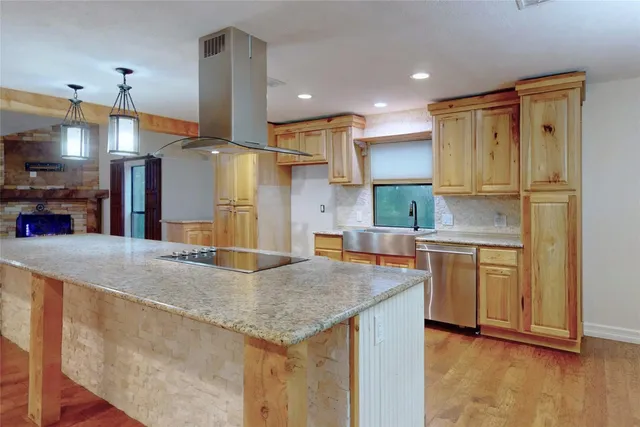 a kitchen with stainless steel appliances granite countertop a sink and a refrigerator