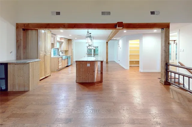 a view of a big room with wooden floor and windows