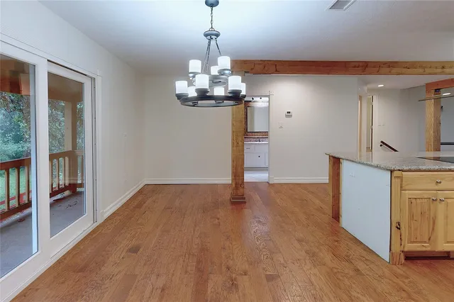 a view of a kitchen with wooden floor and stainless steel appliances