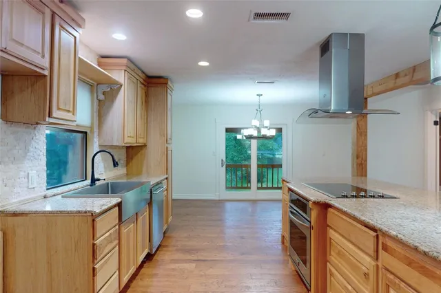 a kitchen with stainless steel appliances granite countertop a sink and a stove