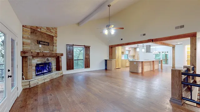 an empty room with fireplace wooden floor and windows