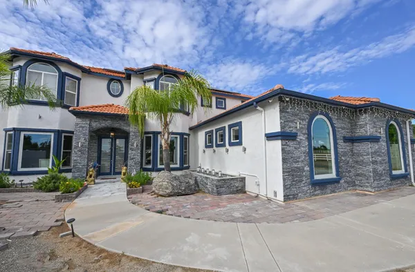 a kitchen with stainless steel appliances kitchen island granite countertop a refrigerator a stove and a sink with wooden floor