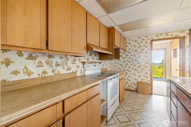 a kitchen with stainless steel appliances a sink a stove cabinets and a window