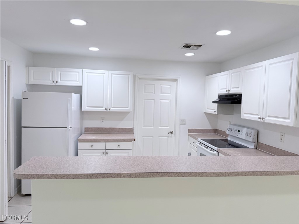 4731 24th Street Southwest Lehigh Acres, FL 33973 - Photo 3 of 8 a kitchen with stainless steel appliances granite countertop a refrigerator a stove a sink a microwave and white cabinets with wooden floor