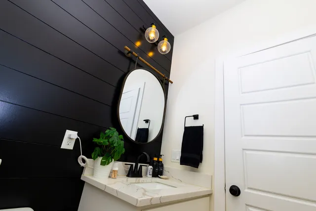 a bathroom with a double vanity sink a toilet a mirror and shower