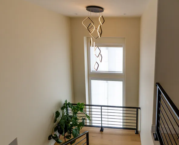a view of a hallway with wooden floor and windows