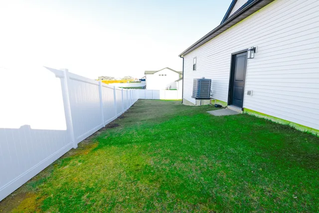 a view of a backyard with brick wall and fence