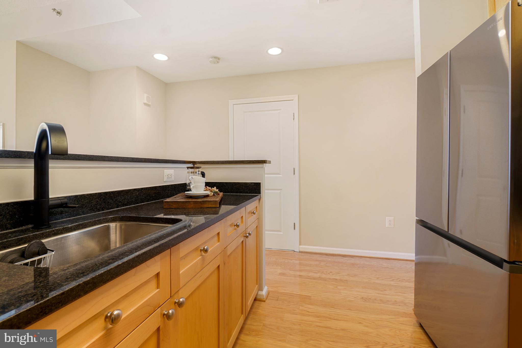 11700 Old Georgetown Road, Unit 214 Rockville, MD 20852 - Photo 12 of 44 a kitchen with granite countertop a sink and a refrigerator