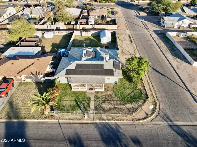 an aerial view of a residential houses with yard
