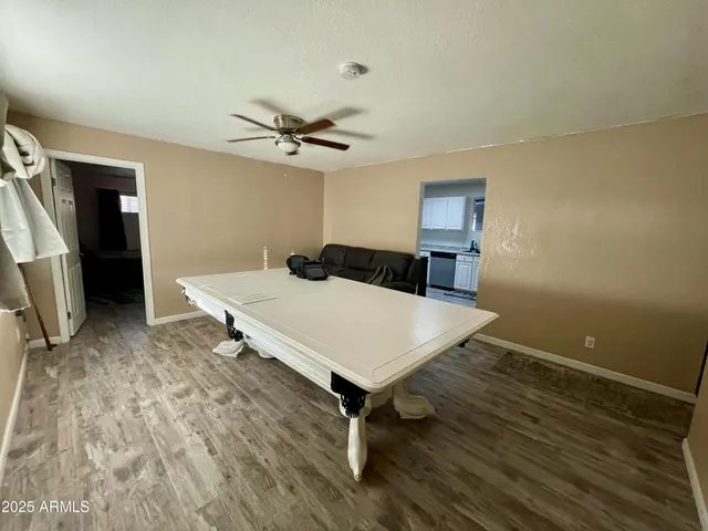 a room with a table and ceiling fan