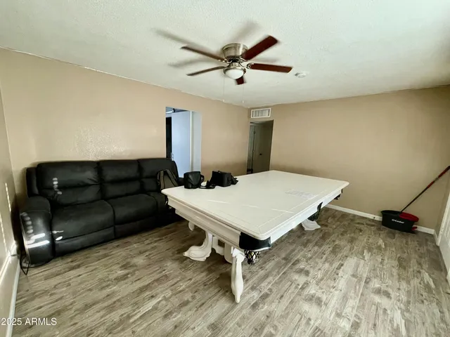 a living room with a bed furniture and a ceiling fan