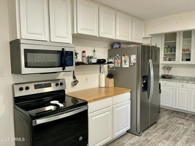 a kitchen with stainless steel appliances granite countertop a refrigerator stove and sink