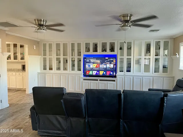 a view of a livingroom with furniture a ceiling fan and windows