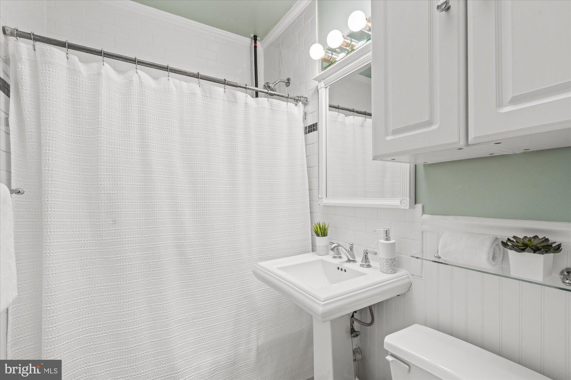 2305 38th Street Northwest Washington, DC 20007 - Photo 26 of 38 a bathroom with a sink a toilet and vanity