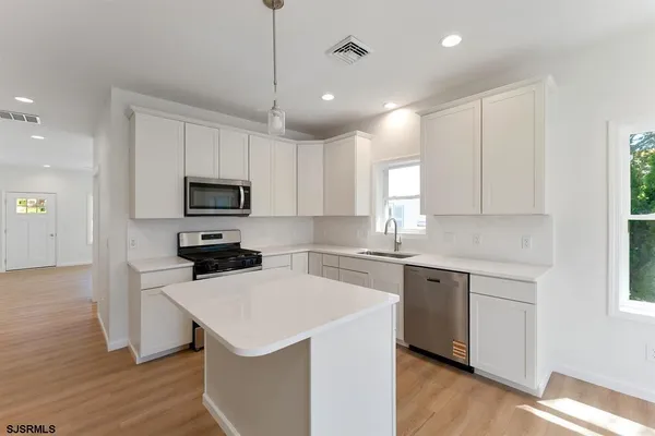 a kitchen with a sink a stove a microwave and cabinets