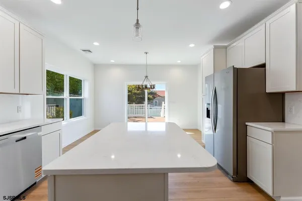a kitchen with stainless steel appliances a refrigerator and a window