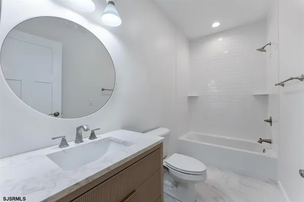 a bathroom with a sink toilet vanity and shower