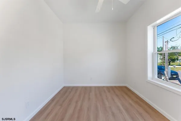 a view of a room that has wooden floor and a window